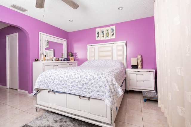 bedroom featuring light tile patterned floors, a textured ceiling, and ceiling fan