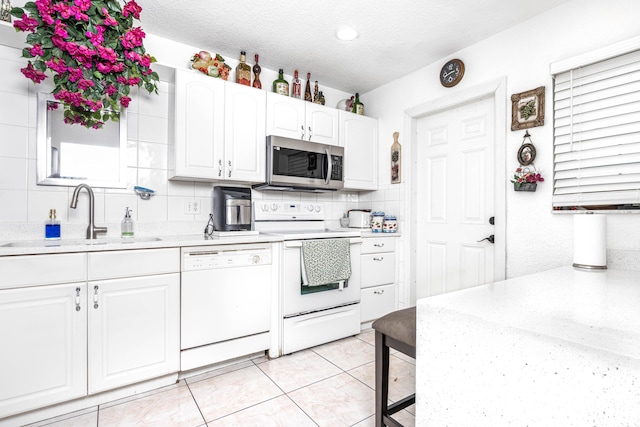 kitchen featuring white cabinetry, range with electric cooktop, dishwasher, sink, and a textured ceiling