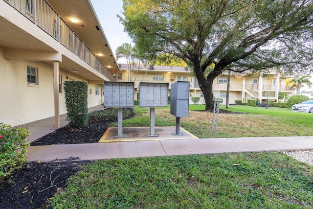 surrounding community with a lawn and mail boxes