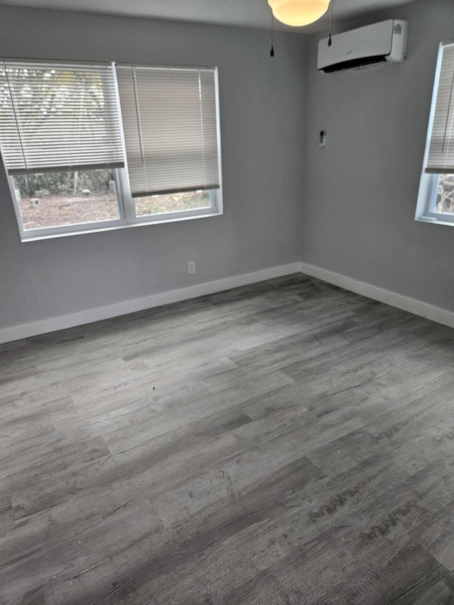 empty room with ceiling fan, wood-type flooring, and an AC wall unit