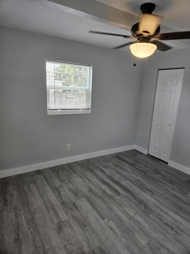 unfurnished room featuring ceiling fan and dark wood-type flooring