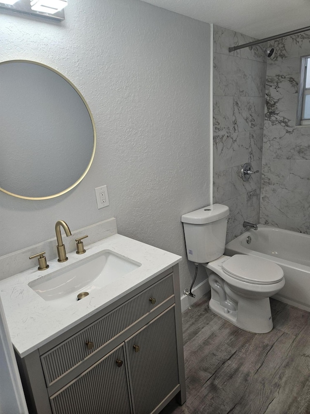 full bathroom featuring tiled shower / bath, toilet, vanity, and hardwood / wood-style flooring