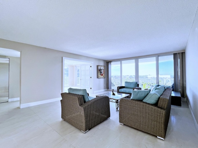 living room featuring a wall of windows and a textured ceiling