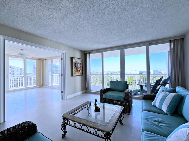 living room featuring floor to ceiling windows, ceiling fan, and a textured ceiling