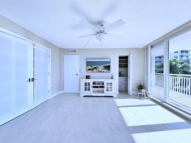 interior space featuring ceiling fan and a textured ceiling