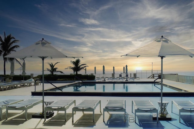 pool at dusk with a patio