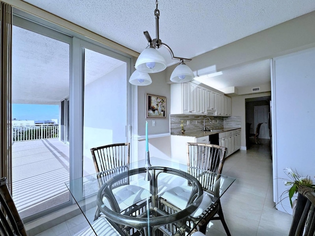 dining room featuring sink and a textured ceiling