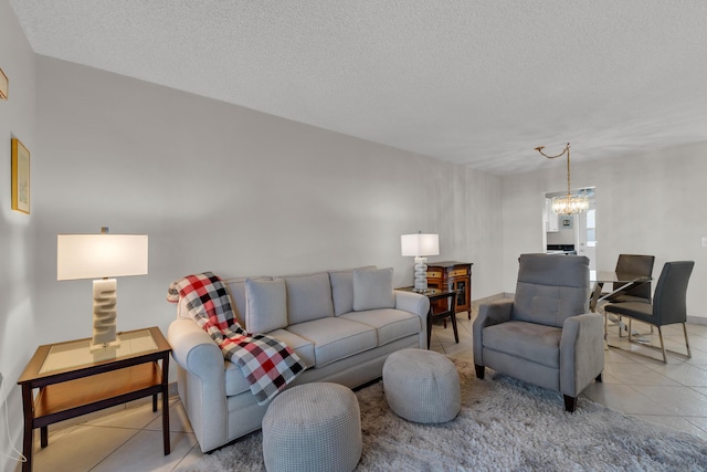 living room featuring light tile patterned flooring, an inviting chandelier, and a textured ceiling