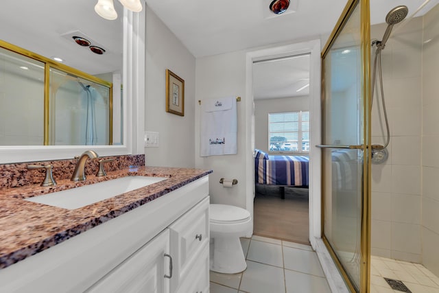 bathroom with toilet, a shower with door, tile patterned floors, and vanity