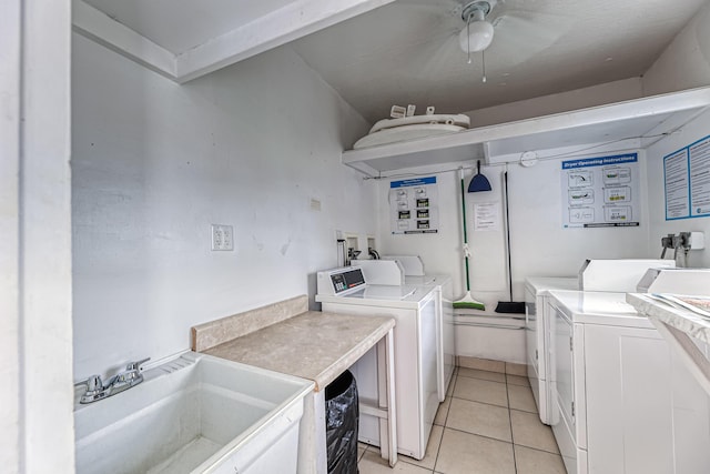 laundry area featuring washing machine and dryer, ceiling fan, light tile patterned floors, and sink