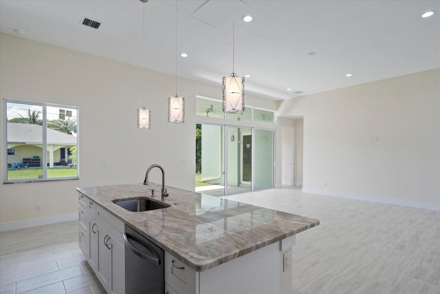 kitchen featuring light stone counters, sink, decorative light fixtures, a center island with sink, and dishwasher