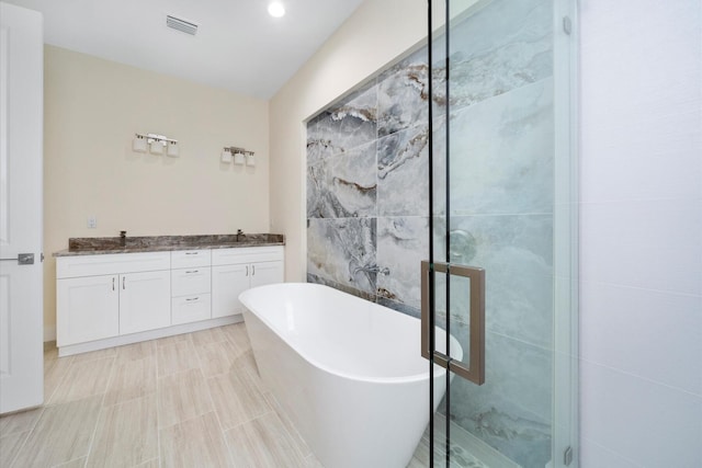 bathroom featuring vanity, a bathtub, and tile walls