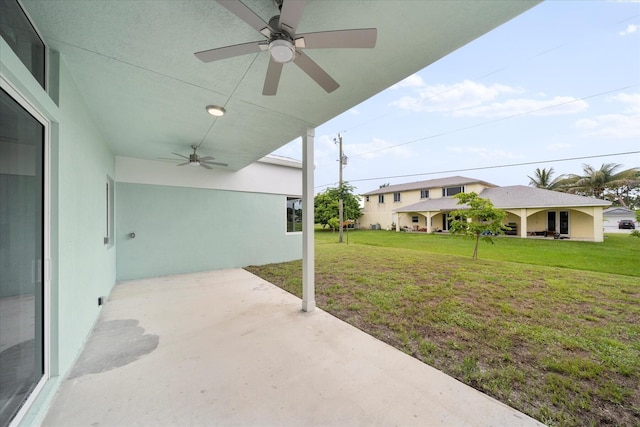 view of yard with ceiling fan and a patio area