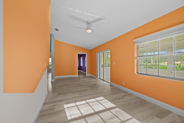 spare room featuring ceiling fan, vaulted ceiling, and light wood-type flooring