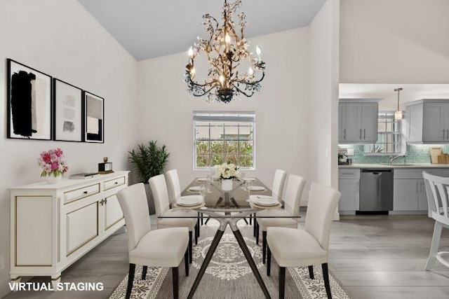 dining room with high vaulted ceiling, a chandelier, and hardwood / wood-style floors