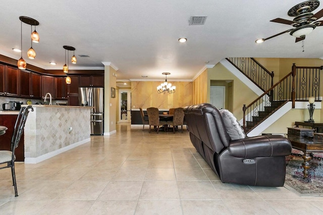 living room featuring ceiling fan with notable chandelier, light tile patterned flooring, sink, and crown molding