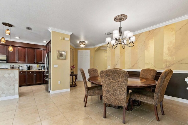 tiled dining space featuring a chandelier and ornamental molding