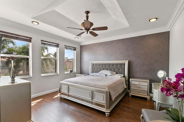 bedroom featuring ceiling fan, dark hardwood / wood-style floors, a raised ceiling, and crown molding