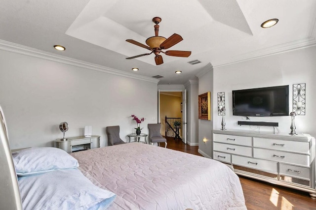 bedroom featuring a raised ceiling, ceiling fan, dark wood-type flooring, and ornamental molding