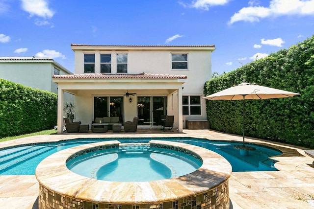 back of property with outdoor lounge area, a swimming pool with hot tub, a patio, and ceiling fan