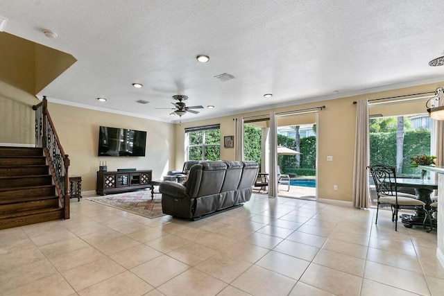 tiled living room with plenty of natural light, crown molding, and ceiling fan