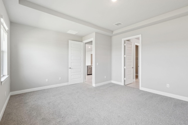 unfurnished bedroom featuring light carpet and multiple windows