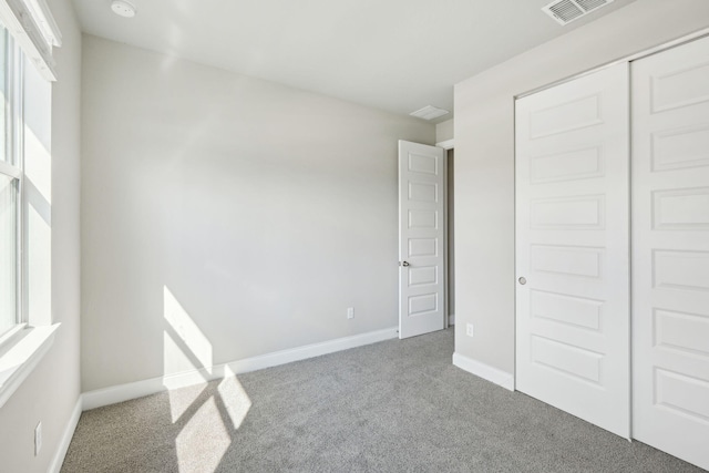 unfurnished bedroom featuring carpet floors and a closet