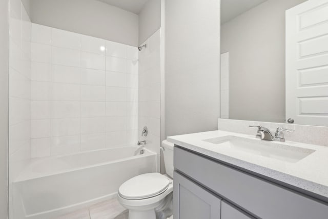 full bathroom with tiled shower / bath, vanity, and toilet