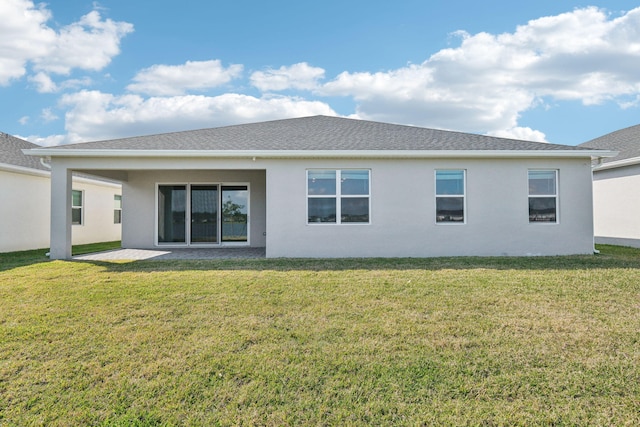 back of property with a yard and a patio area