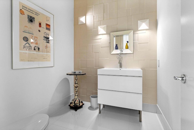 bathroom with toilet, vanity, and tile patterned flooring