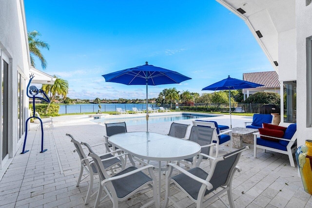 view of patio / terrace featuring a fenced in pool and a water view