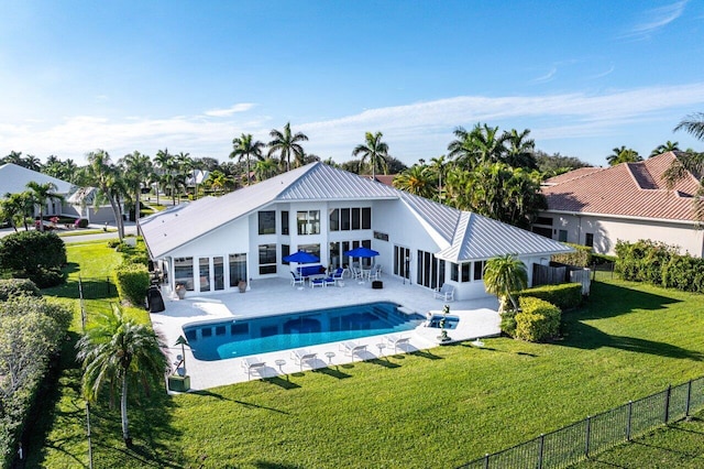 rear view of house with a patio area, a fenced in pool, and a yard