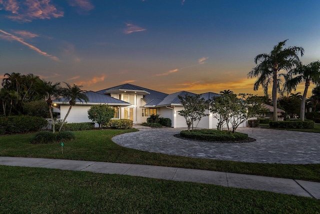 view of front of property featuring a lawn and a garage