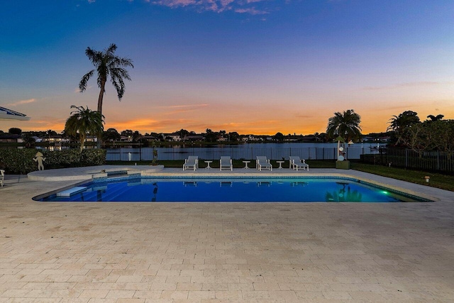 pool at dusk with a patio