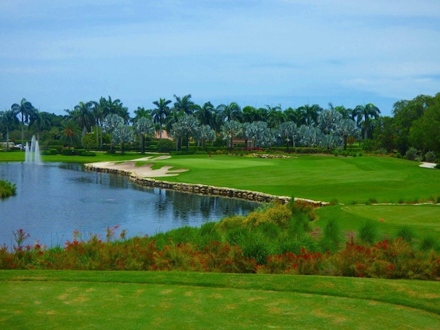 view of property's community featuring a lawn and a water view