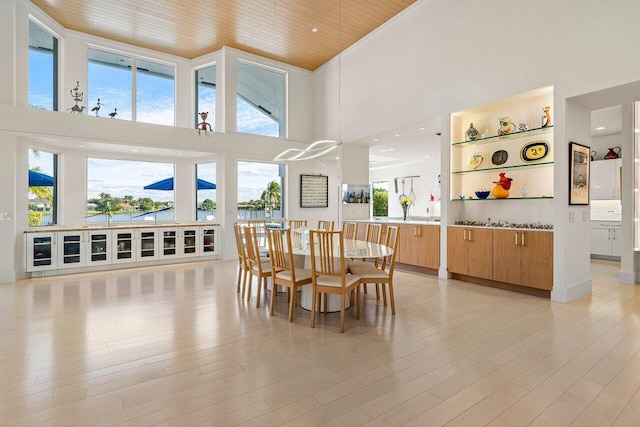 dining area with a high ceiling, a healthy amount of sunlight, and wood ceiling