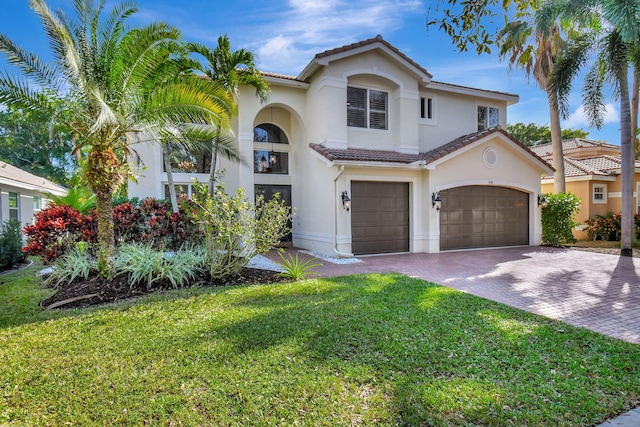 mediterranean / spanish-style house featuring a front lawn and a garage