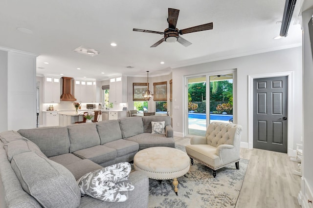 living room with ceiling fan, light hardwood / wood-style flooring, and ornamental molding