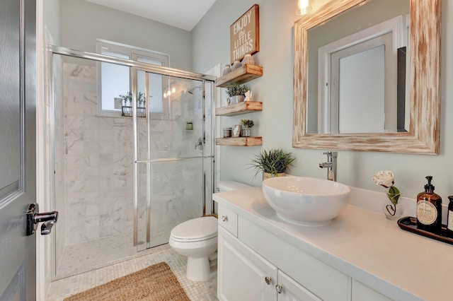 bathroom featuring tile patterned floors, vanity, a shower with shower door, and toilet