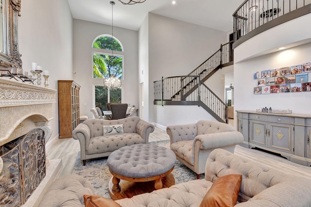 living room featuring a notable chandelier, light wood-type flooring, and a towering ceiling