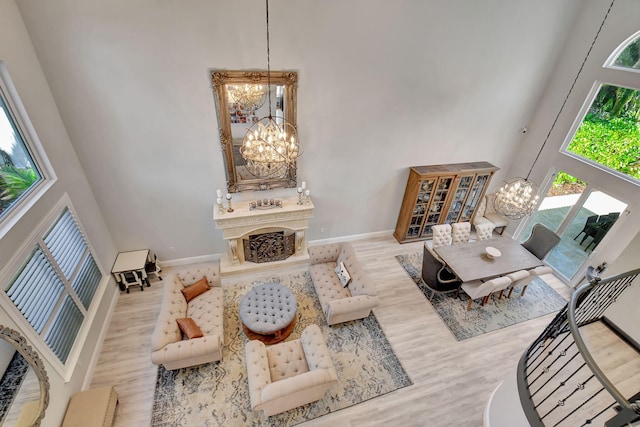 living room with hardwood / wood-style flooring, a high ceiling, and an inviting chandelier