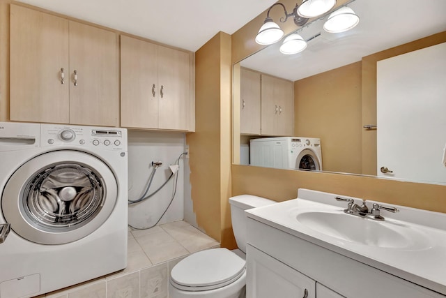 bathroom featuring toilet, vanity, washer / dryer, and tile patterned floors