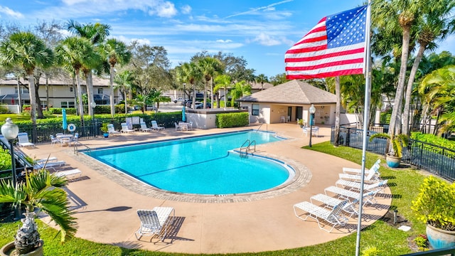 community pool with fence and a patio