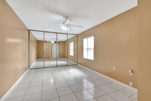 18 Amherst Ct Unit B, Royal Palm Beach, FL 33411 - unfurnished bedroom featuring a textured ceiling, baseboards, a ceiling fan, and light tile patterned flooring