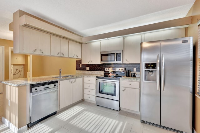 18 Amherst Ct Unit B, Royal Palm Beach, FL 33411 - kitchen featuring appliances with stainless steel finishes, a sink, backsplash, light tile patterned floors, and light stone countertops