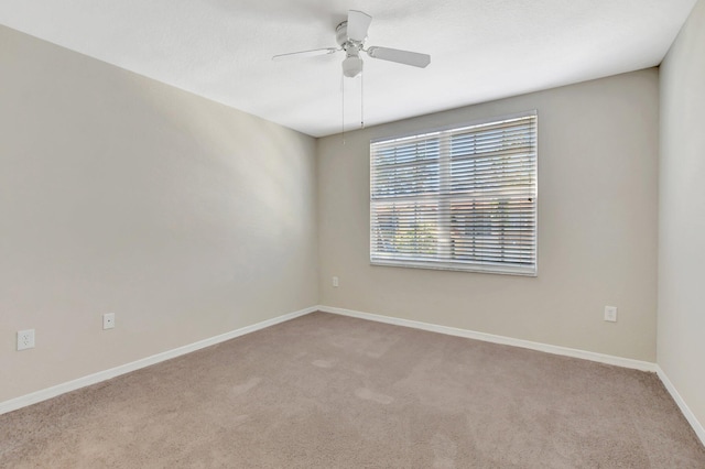 carpeted spare room with ceiling fan