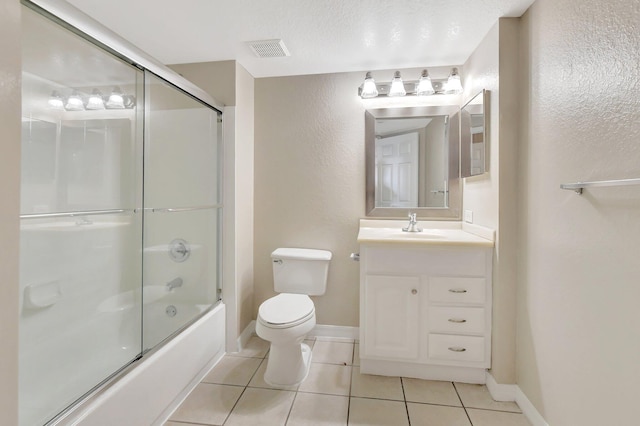 full bathroom with tile patterned flooring, vanity, toilet, and bath / shower combo with glass door