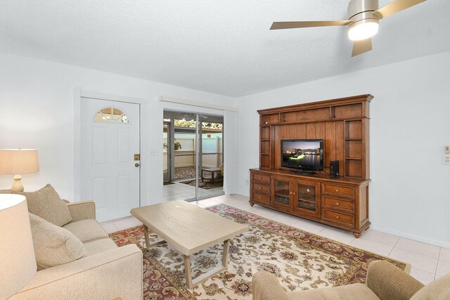 living room featuring tile patterned floors, ceiling fan, and a textured ceiling