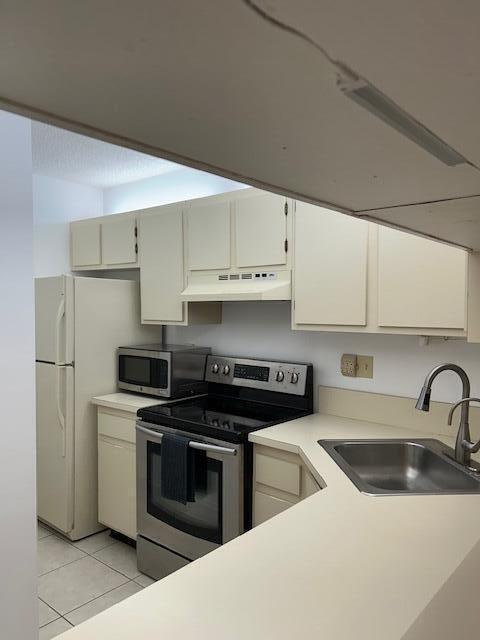 kitchen featuring sink, light tile patterned floors, and stainless steel appliances