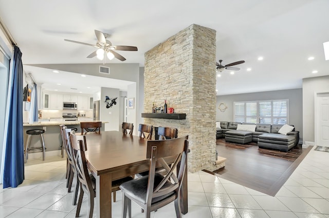 tiled dining area featuring ceiling fan and lofted ceiling